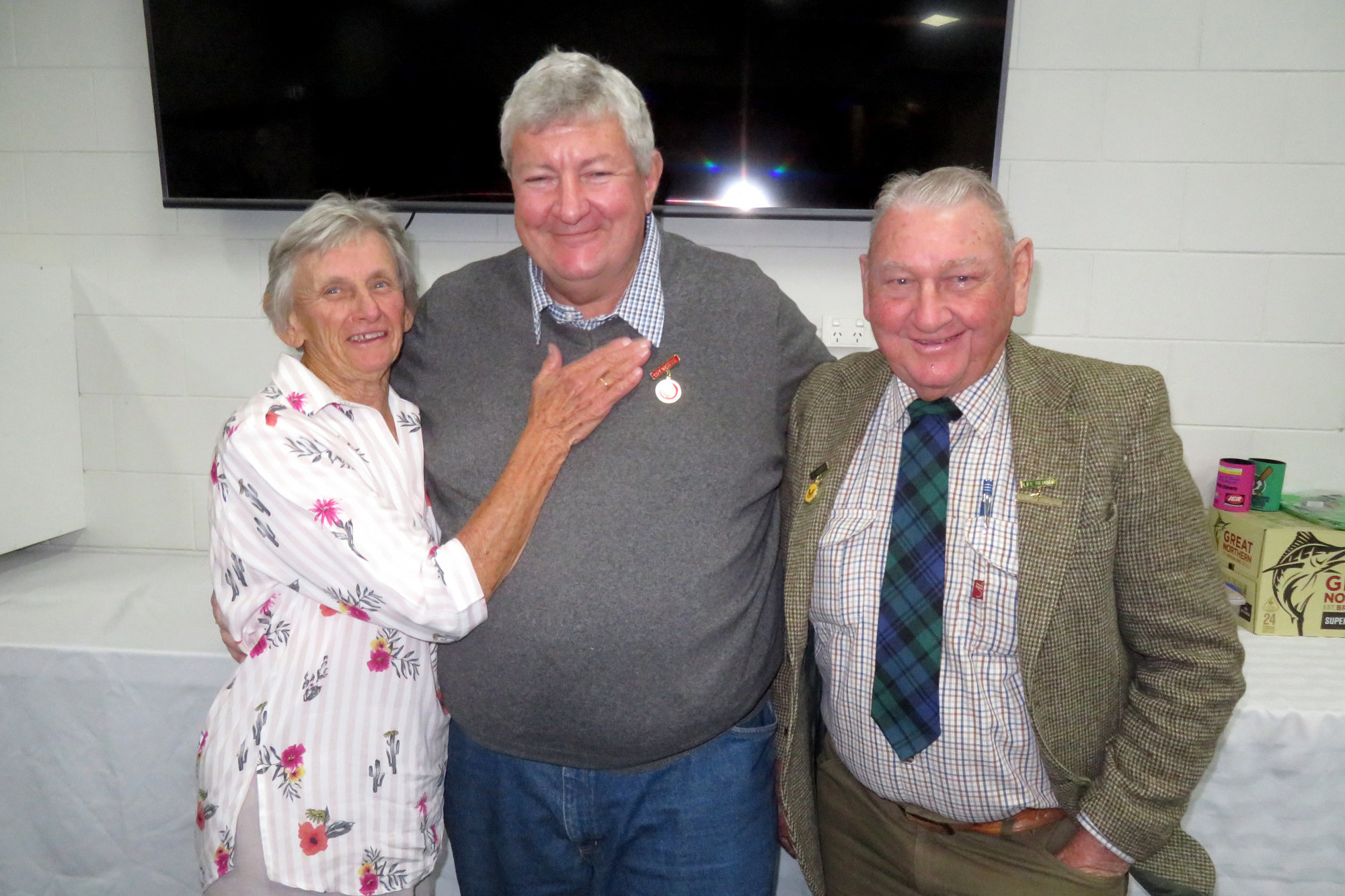 Lyn Bass and Ray Chicken present Ray Madsen with his Pittsworth Cricket Club life membership badge.