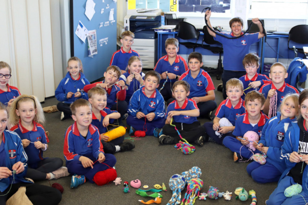 Back Plains State School students busily doing crochet work to add to the collection they have already produced, such as the articles at the front of the photo. The founders of the scheme to provide animals for sick children in hospital are Zoey and Lily, who are at the left and right of the picture.