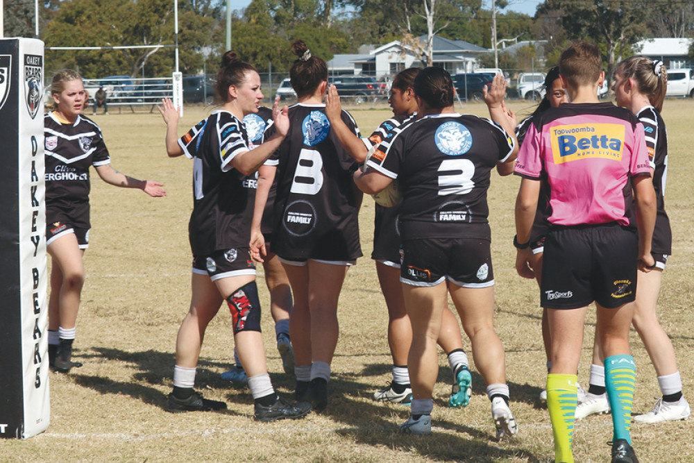 The Oakey team get around centre Clarissa Janes after the bustling No.3 touched down for her fourth try.