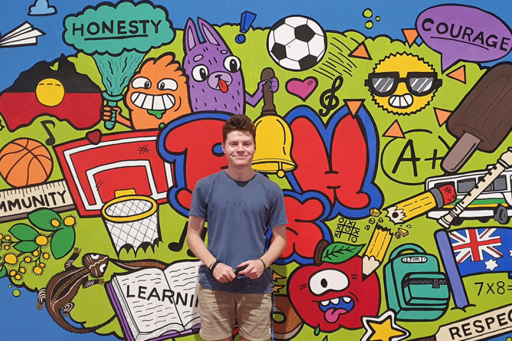 Connor Byrd with the mural he designed.