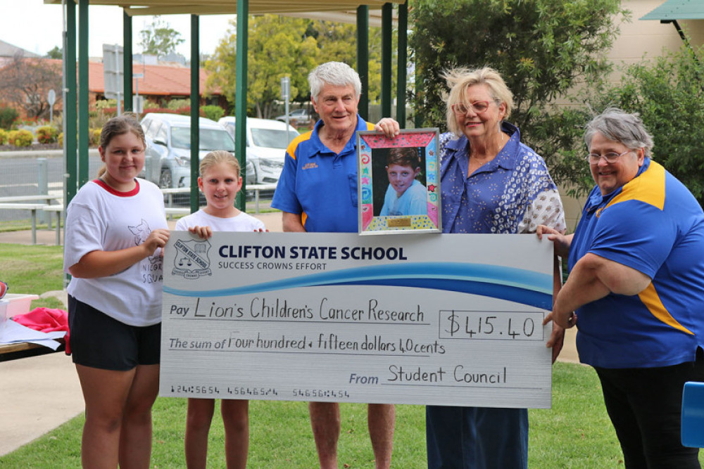 From left: Clifton State School school captains Lucy and Mia, Clifton Lions Club’s Peter Bisdee, a photograph of James Bazley being held by his mother Louise Bazley and Lions President Maryann Bisdee.