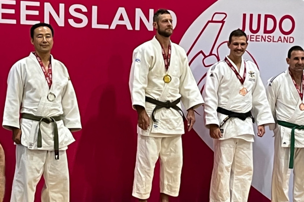 Craig Hindmarsh (centre) standing on the podium with his gold medal.