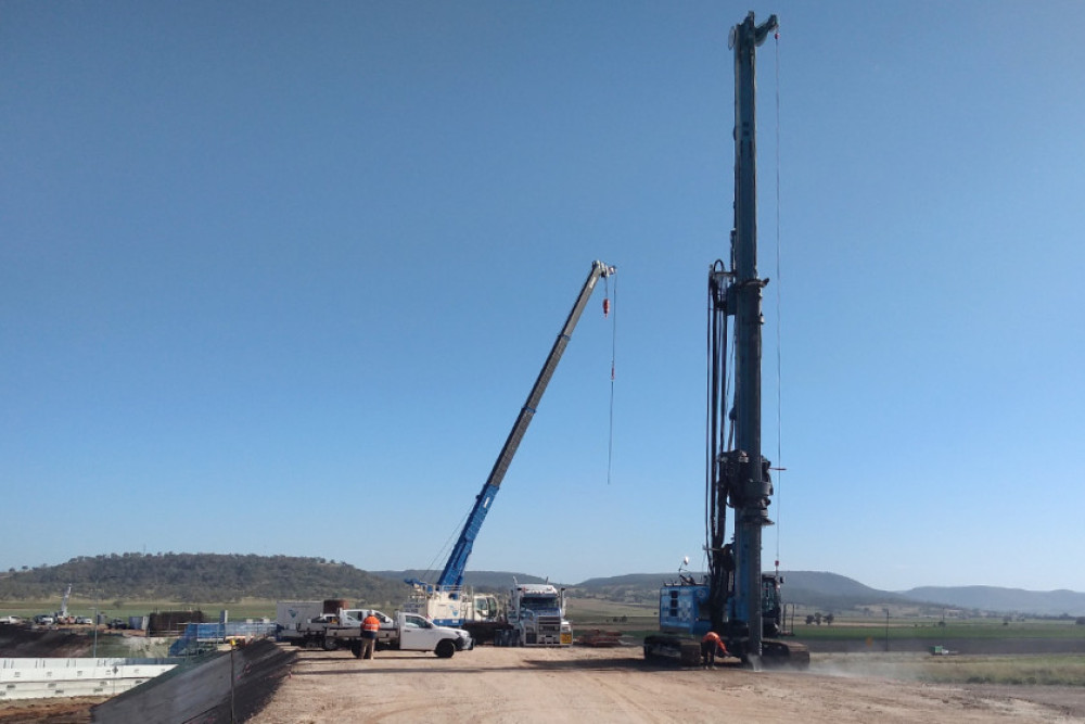 The drill rig was used to bore down 26 metres to install the bridge foundation piles for the overpass at Eight Mile intersection. The crane in the background was used to lower in reinforcing steel to the abutment piles. (Photo courtesy Department of Transport and Main Roads)