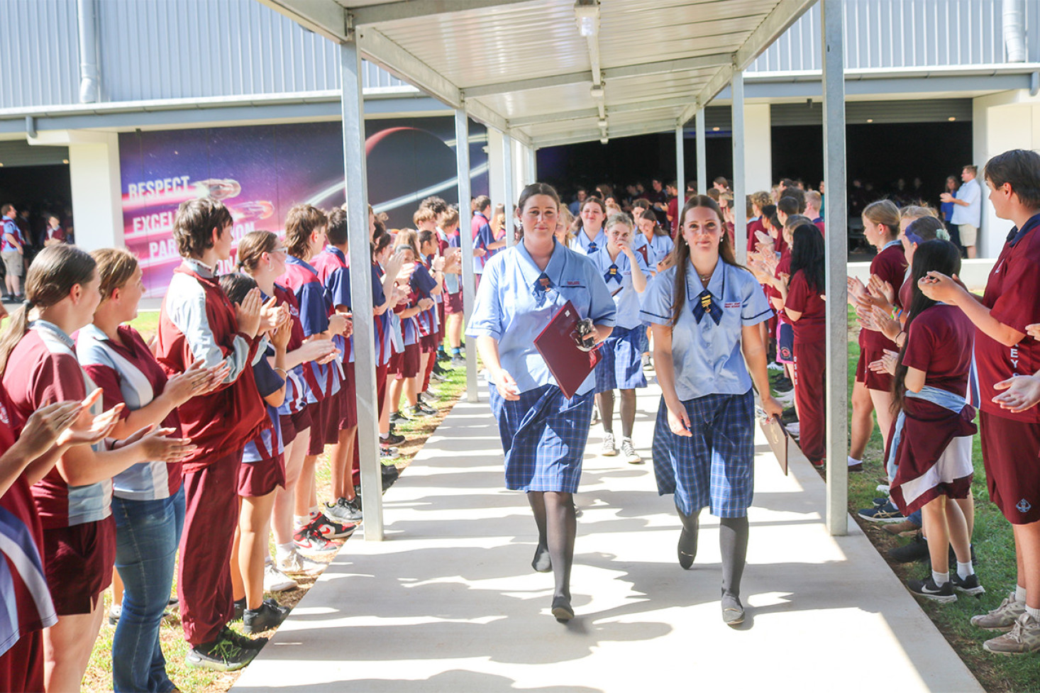 OSHS Year 12s depart through the traditional farewell guard of honour formed by the younger students.