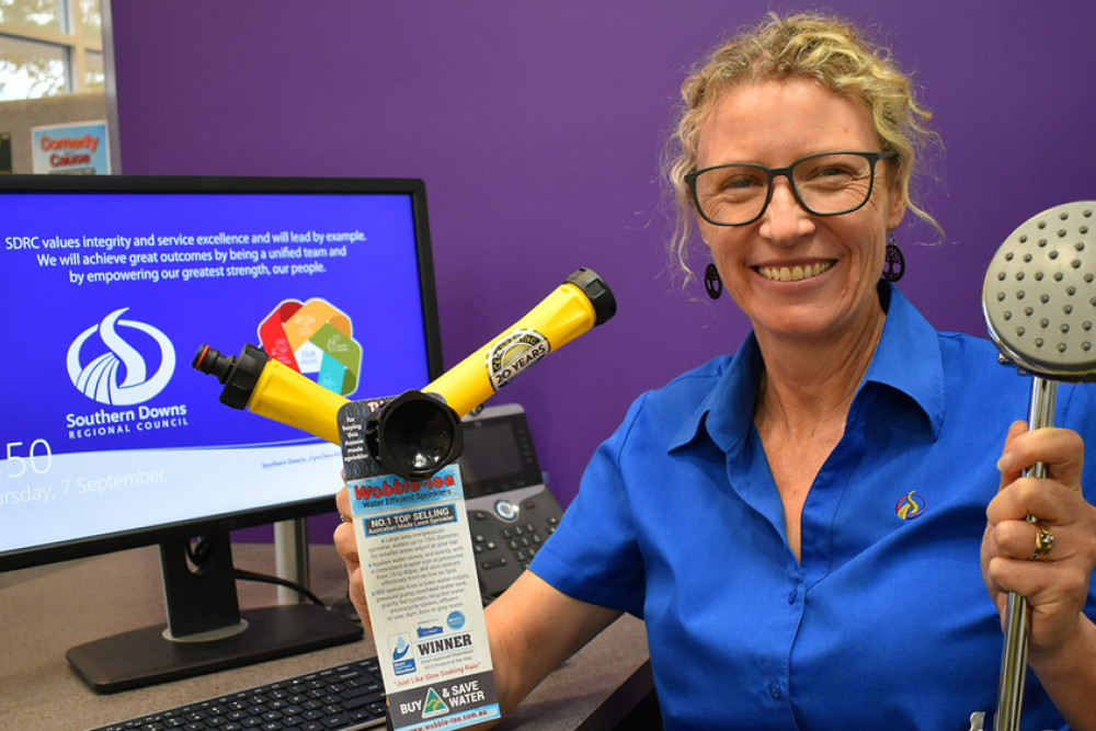 Southern Downs Regional Council staff member Monique displaying the water efficient showerheads and sprinklers that can help reduce water consumption for waterwise residents.