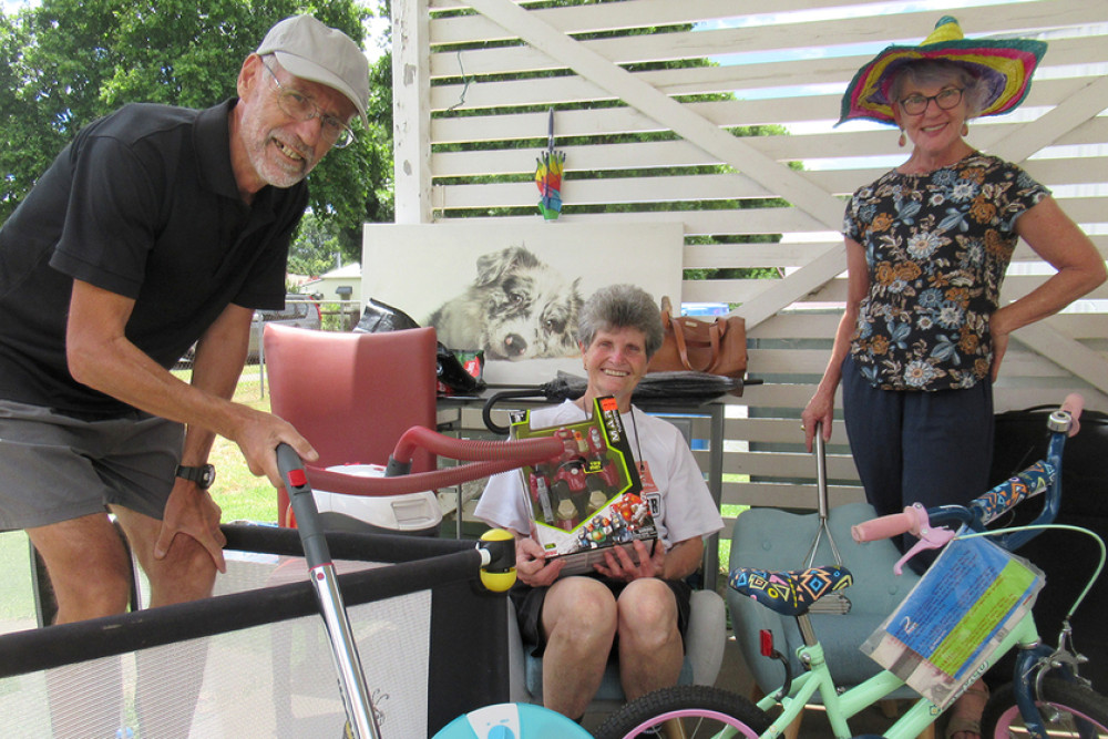 Bob and Di Miller with Julie Leggatt - displaying the goods they have delivered to the Salvation Army Shop in Allora.