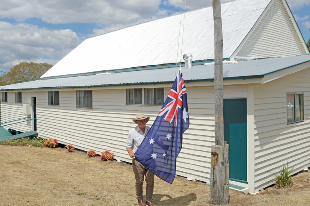 ABOVE: Bruce Dascombe hoists the Australian flag on the flagpole that his father installed in the 1950s.