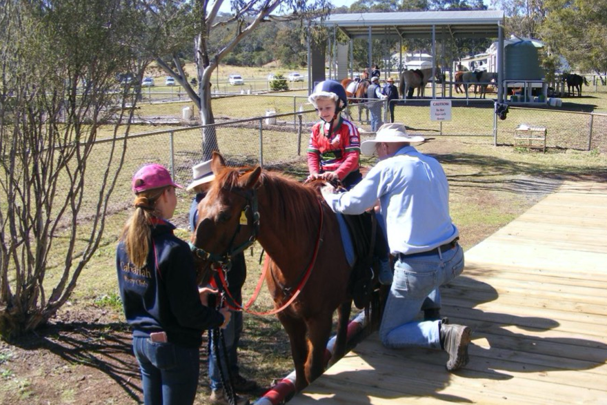 Coach Willi Singleton making use of the new ramp to ensure the rider is safely mounted and secure in the saddle.