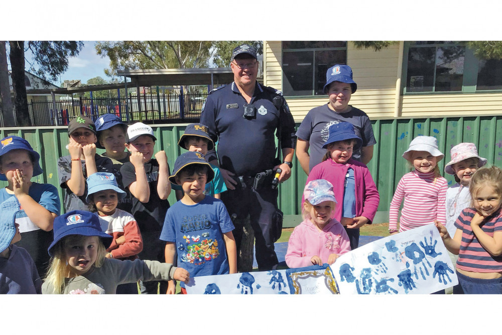 Senior Constable Warren Schefe with a group of the Kids Patrol Oakey Academy children.