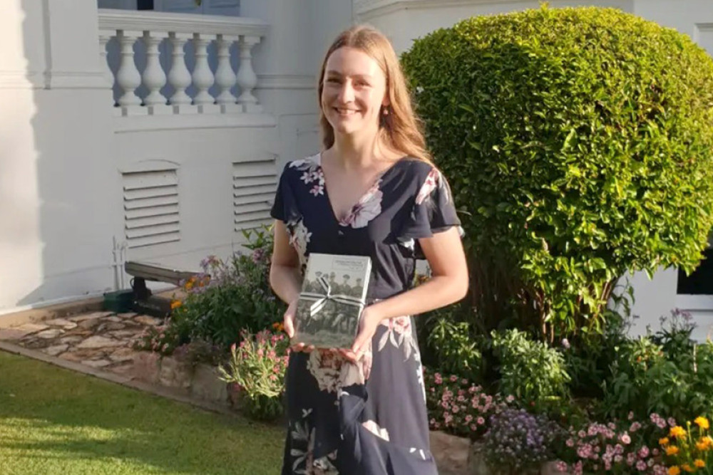 Naomi Simpson at Parliament House, proudly displaying a copy of the journal in which her article was published.