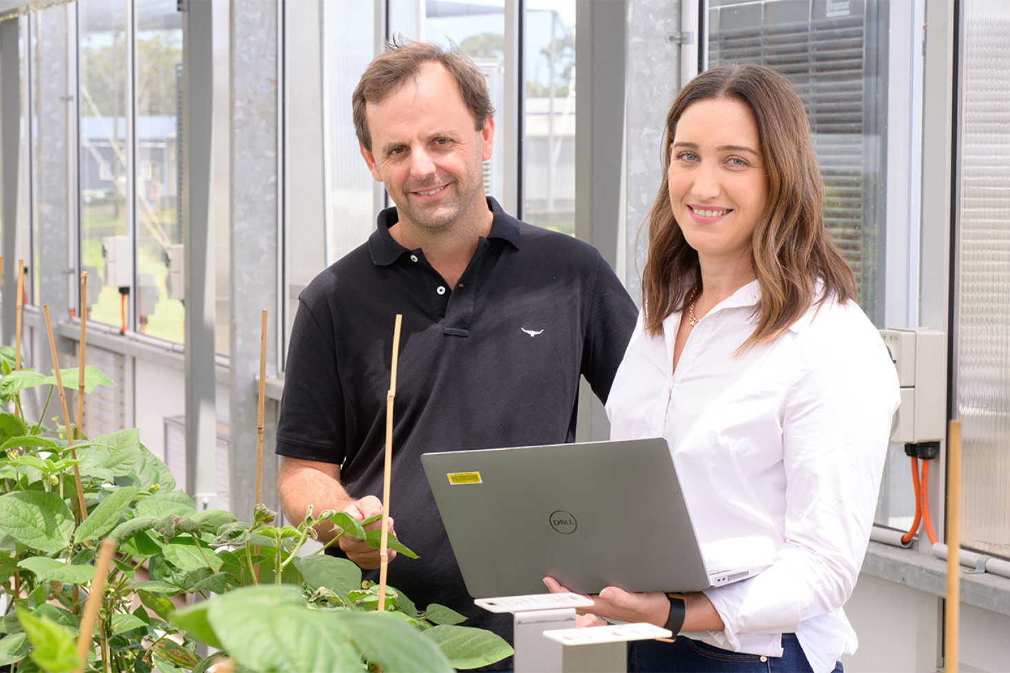 Neil Robinson and Lauren Goldspink in the glasshouse showcasing the PlantEye 3D Multispectral Scanner.