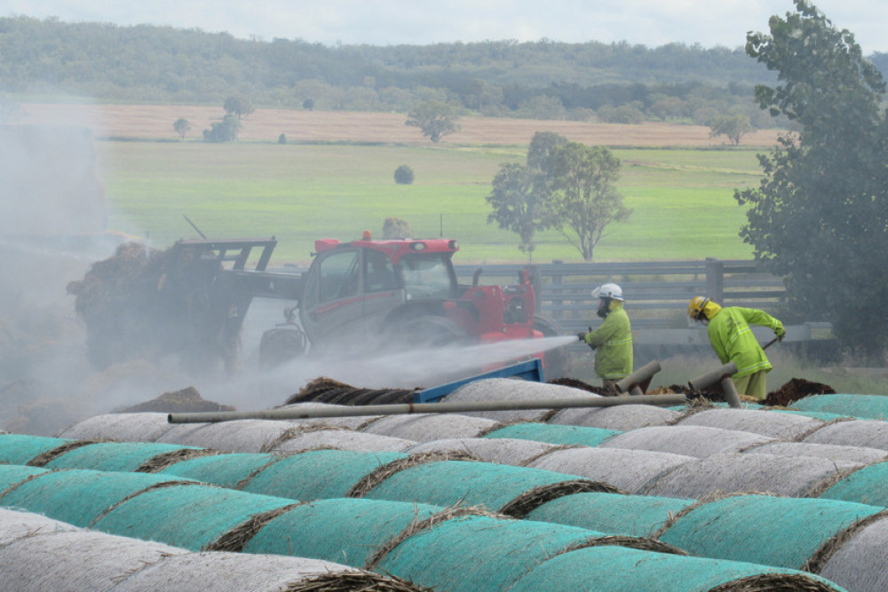 Firefighters quelling the smouldering stack of rectangular bales on the Doolan Road farm were able to prevent the fire spreading to nearby round bales.