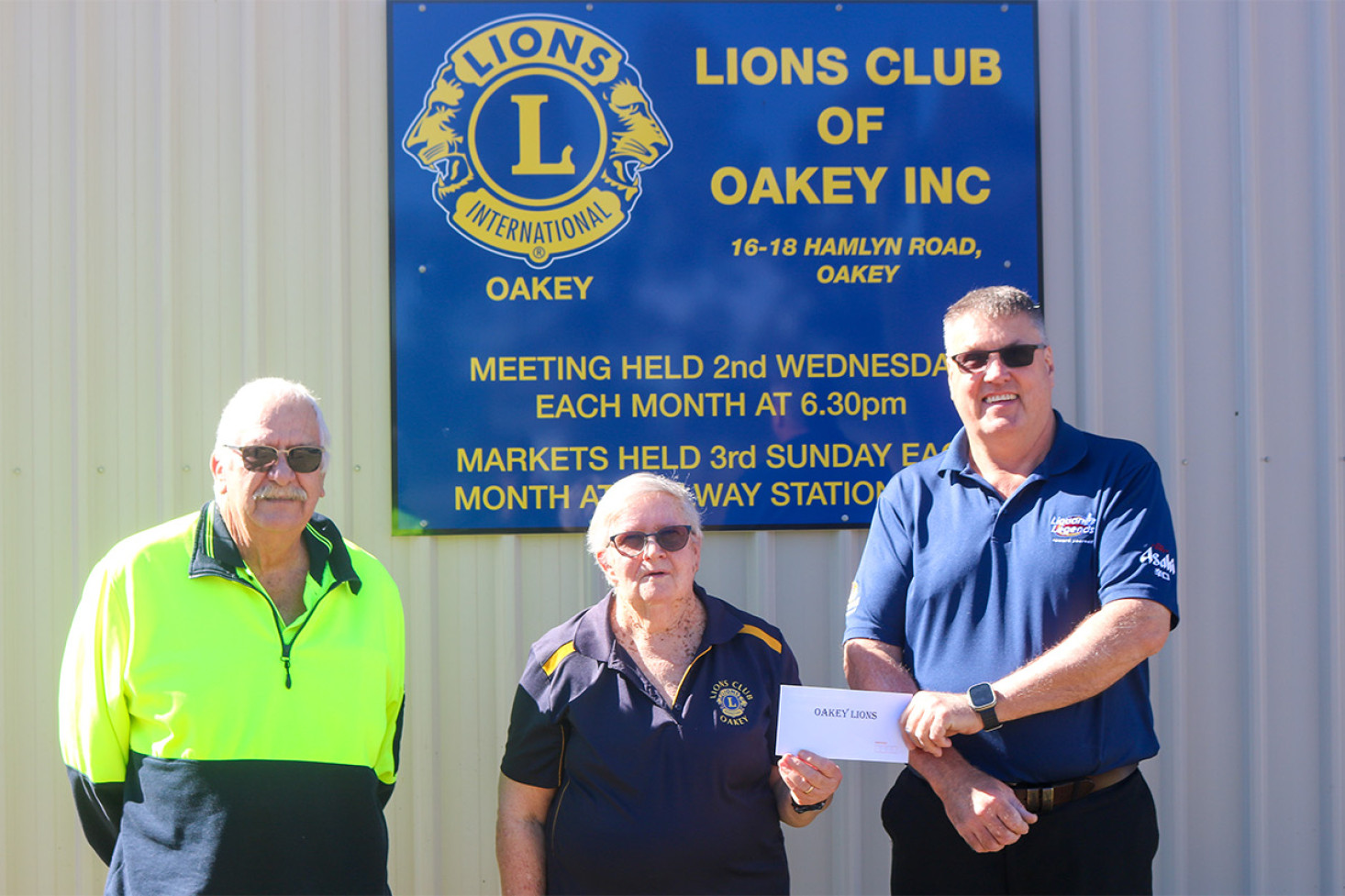 John Webster (left) and Michael Carpenter (right) with the latest Community Chest recipient Julie Ernst, representing Oakey Lions.