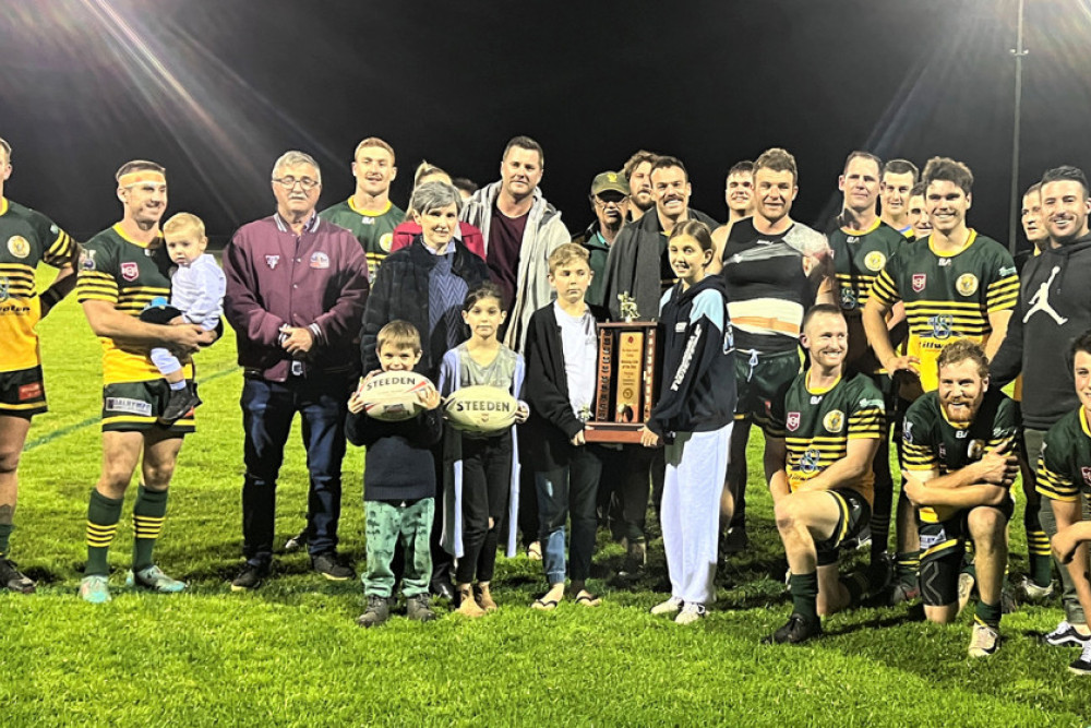 Wattles Warriors A Graders celebrate the club’s Ragh Family Trophy success with family members at Platz Oval.