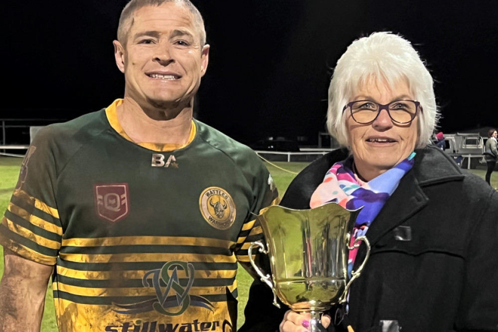 Wattles Captain/Coach Travis Burns receives the Rod Frahm Memorial Cup from Mrs Janette Frahm.