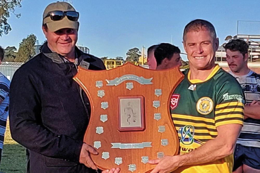 Wattles skipper Travis Burns is presented with the Dan Ryan Memorial Shield by Matt Ryan after the A Grade game against Brothers on Sunday.