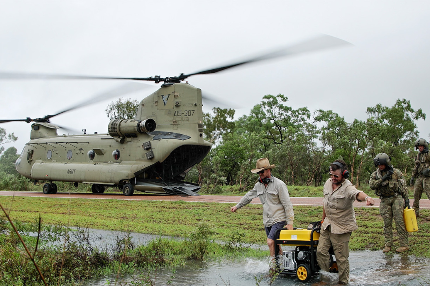 Mr Scott and Tim Broodbank from Telstra Service provide generator support to the town of Ingham during the North Queensland floods, having been transported by Chinook. Photo: LSIS Susan Mossop/ Defence