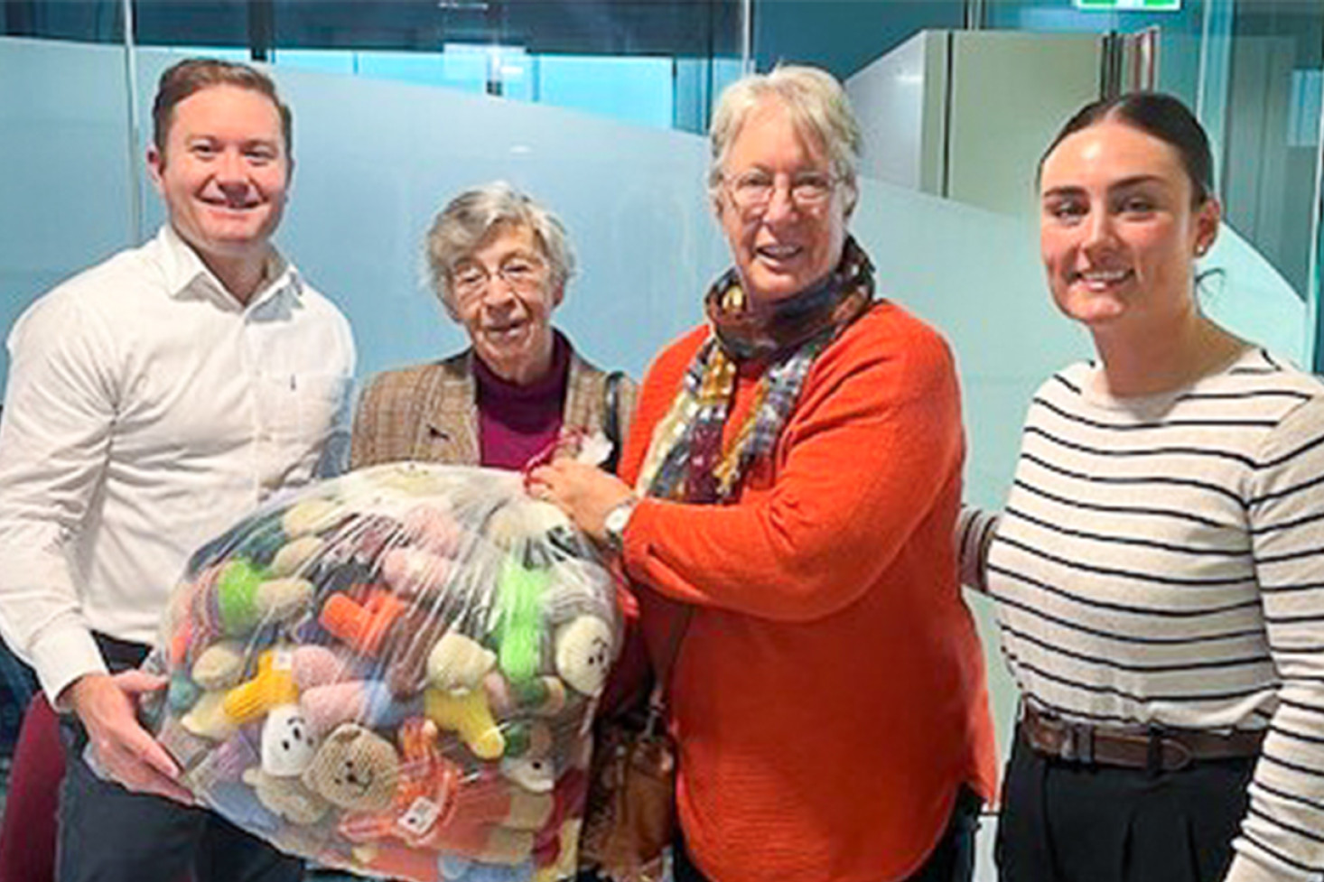 Senior Constable Rhett Turner, Heather Miller, (a Trauma Teddy knitter), Erica Paynter (Westbrook Trauma Teddy Group Leader) and Constable Courtney Briese at the Police Child Protection Unit in Toowoomba.