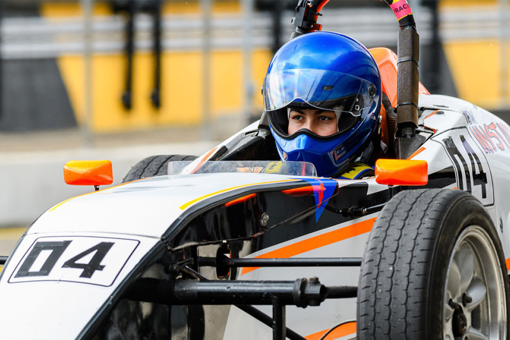 Yamuna has her serious race day face on while waiting to race her sleek Formula Vee motor vehicle.